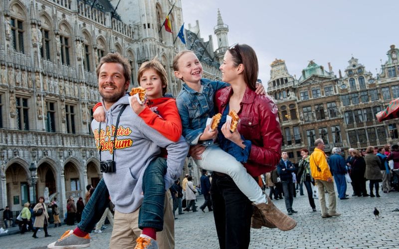 Une famille souriante en Belgique sur la place principale. 