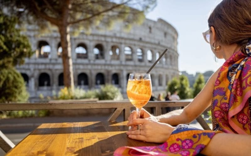 Femme avec cocktail devant le Colisée en Italie. 