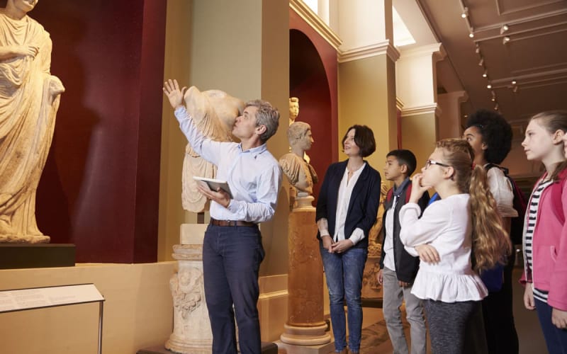 Guide d'un musée avec des touristes et expatriés. 