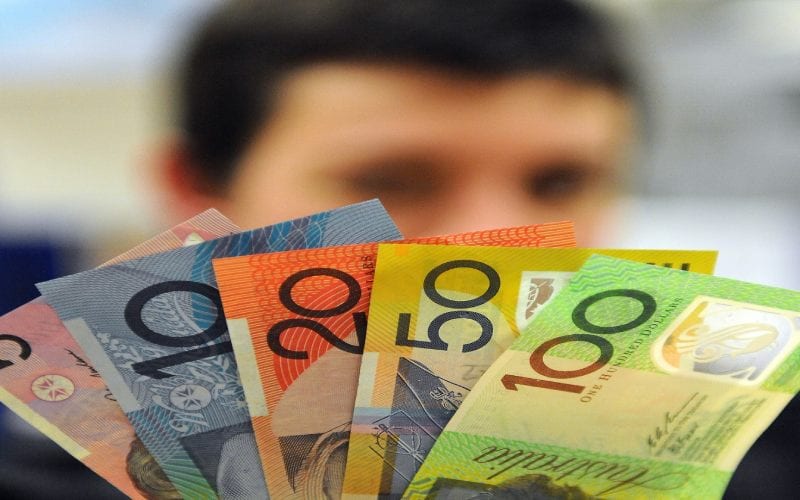 Un homme avec des billets Australien. 