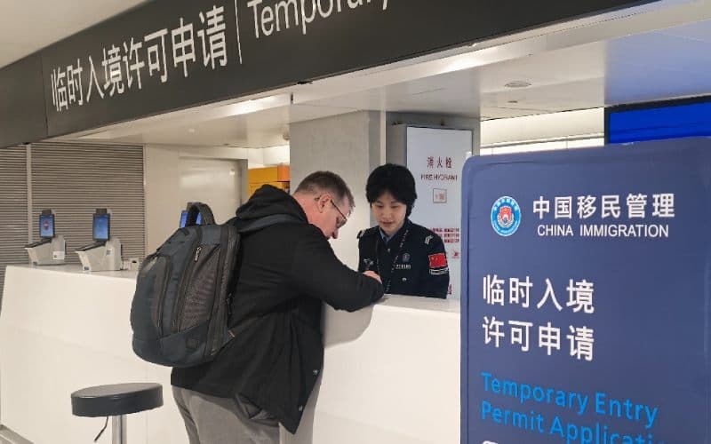 Homme remplissant des documents au bureau d'immigration chinois. 