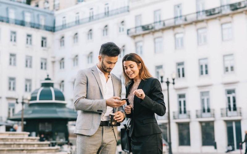 Un homme et une femme au Portugal regardant un téléphone. 