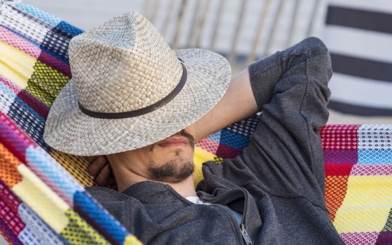 Un homme faisant la sieste, avec un chapeau, en Espagne. 