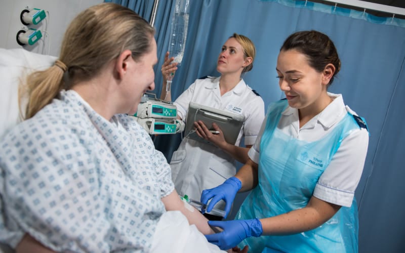 Des infirmières au Royaume Uni consultant un patient. 