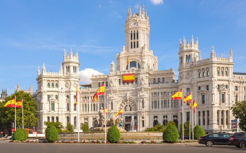 Une mairie typique de Madrid sous le soleil avec des drapeaux espagnols. 
