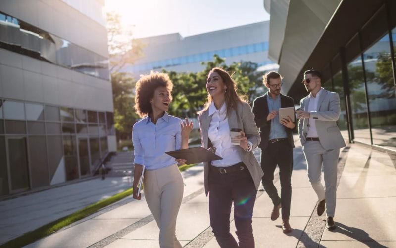 Quatre jeunes professionnels discutant en dehors des bureaux. 