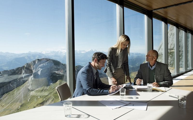 Réunion d'affaires avec vue sur les alpes suisses.