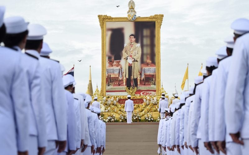 Plusieurs soldats devant la photo du roi thaïlandais. 
