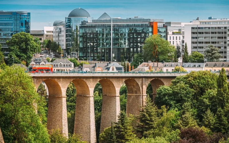 Ville de Luxembourg moderne avec un train et un pont. 