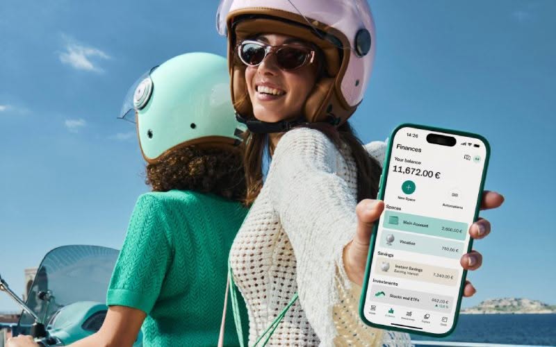 Femme à moto et montrant son téléphone avec l'application bancaire N26.