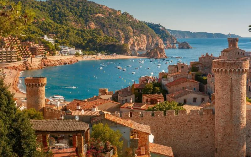 Une plage typique d'Espagne avec eau bleue et architecture locale. 